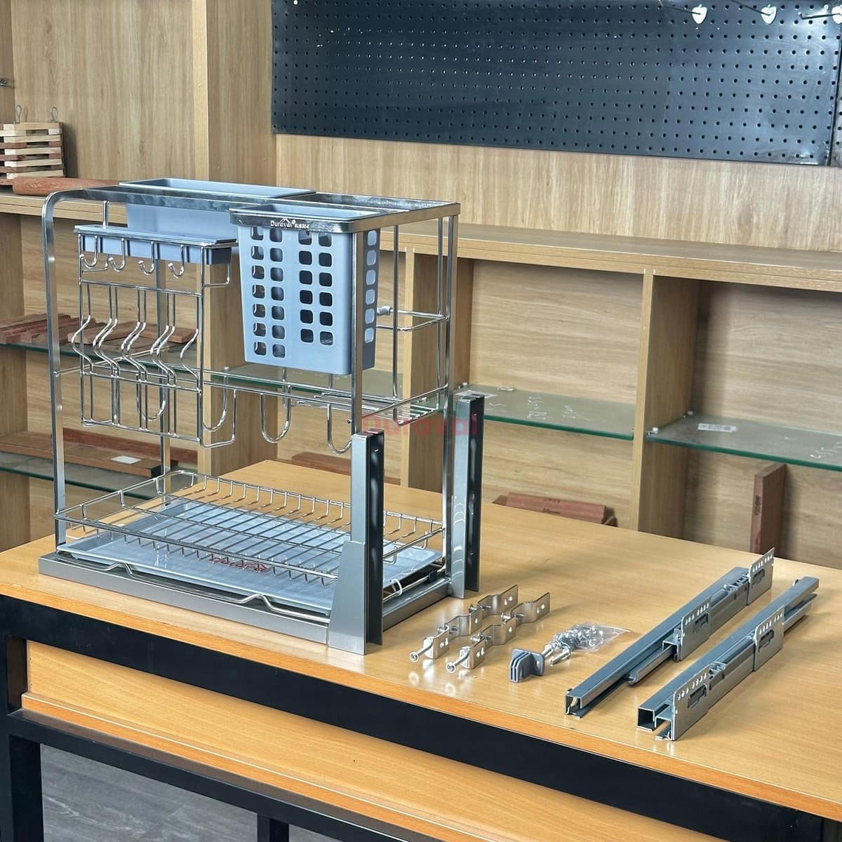 Giá dao thớt inox 304 Duraval D6241 đặt trên bàn, có giỏ cài dao, ống đũa, tầng dưới để thớt, bên cạnh là cặp ray và pát lắp