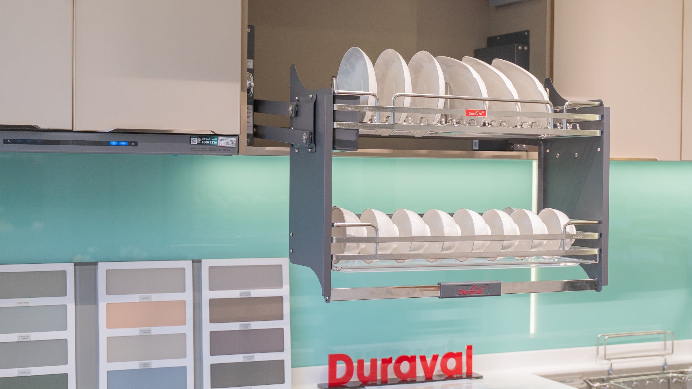 Ảnh chụp tại showroom Duraval: giá bát nâng hạ inox 304 D6259 hạ từ tủ trên, đĩa xếp tầng trên, bát dựng đứng tầng dưới