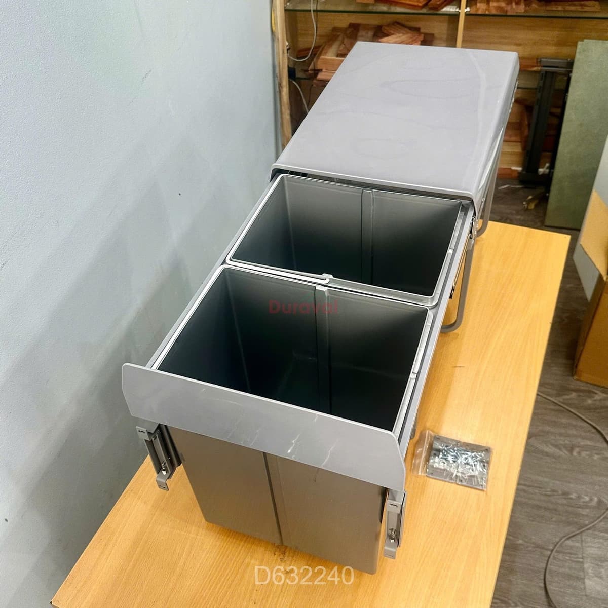Thùng rác 2 ngăn tủ bếp liền cánh Duraval D6322: hai thùng nhựa xám trong khung ray, kèm túi vít; góc ảnh in mã D632240