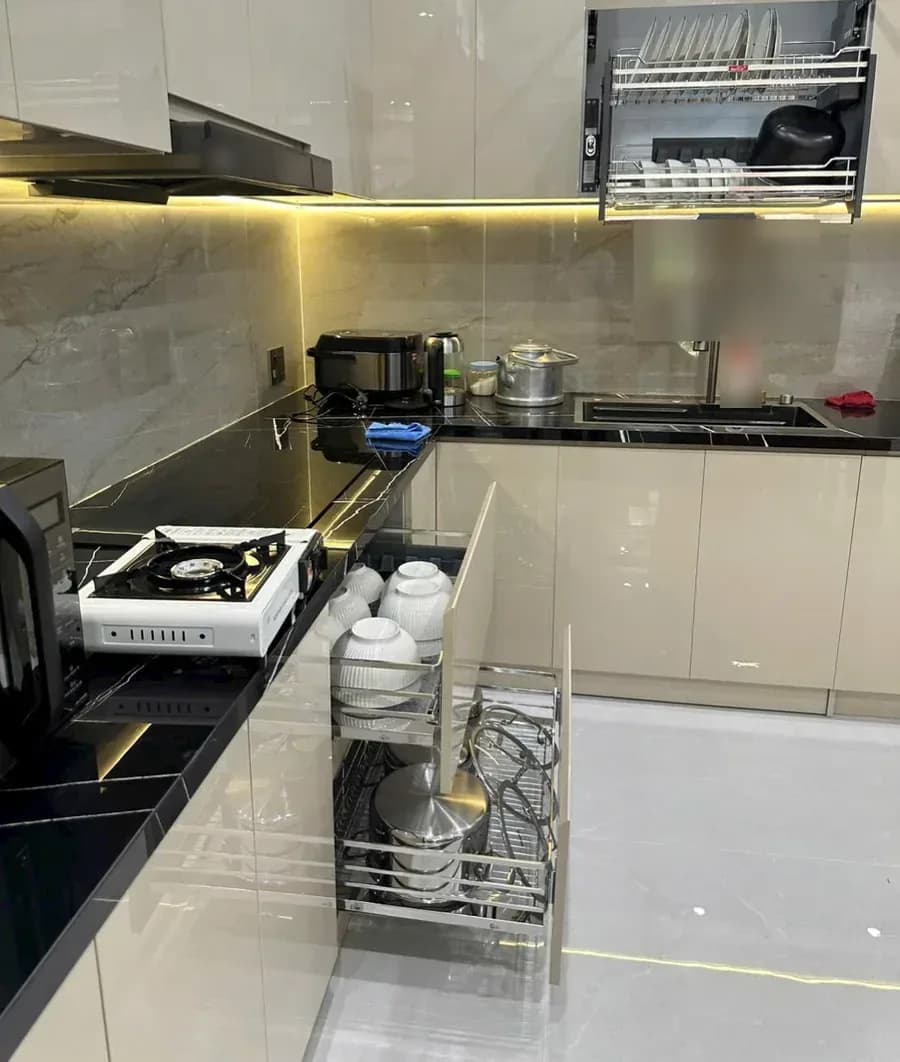 Bếp khách dùng giá xoong nồi kéo ra ở tủ dưới và giá bát nâng hạ ở tủ trên, ảnh khách gửi tháng 9/2026